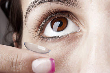 woman holding a contact lens on finger tip